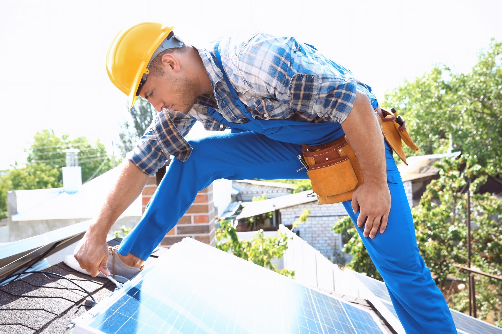 Installateur posant des panneaux solaires photovoltaïques sur toiture